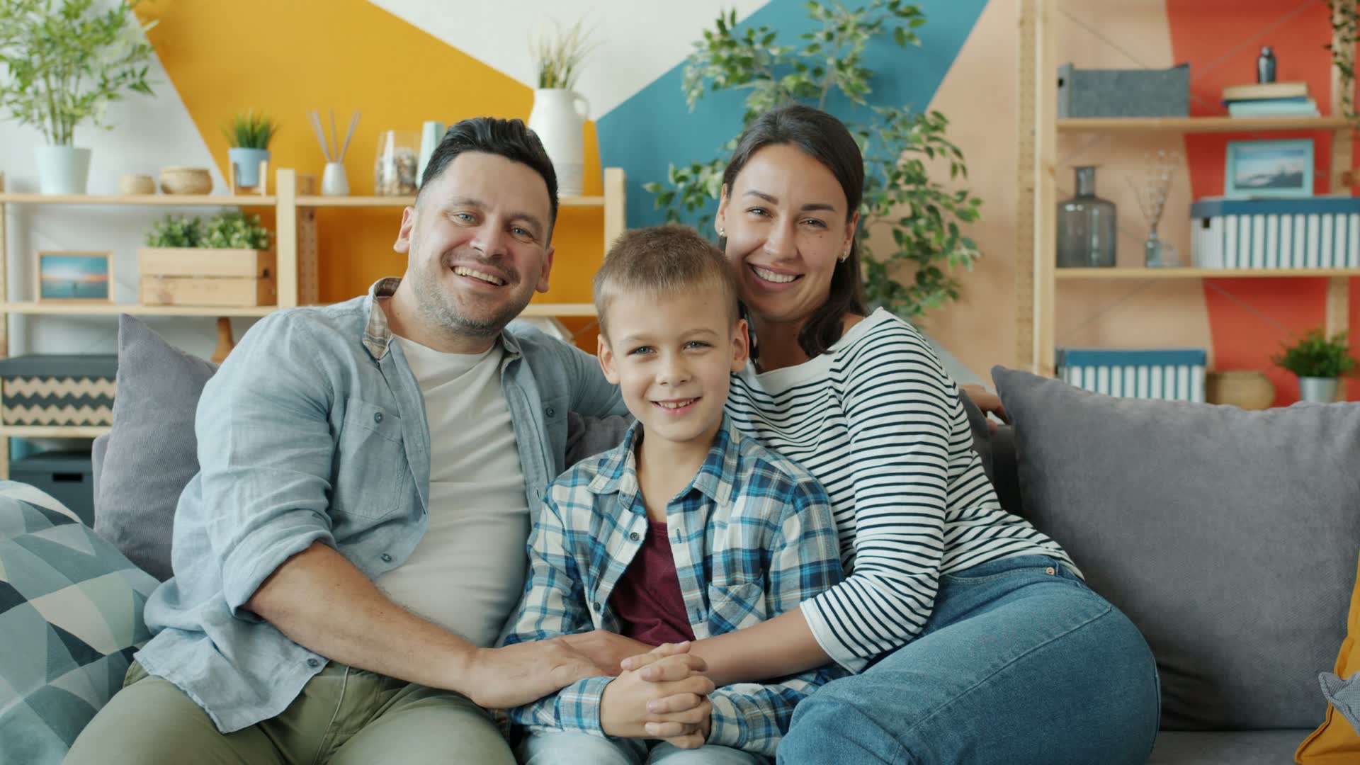 Happy family of three smiling on a couch