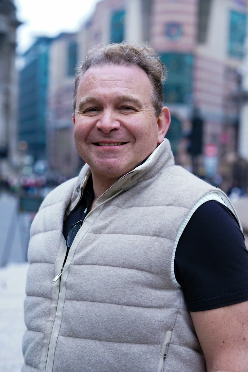 Smiling man in a vest outdoors