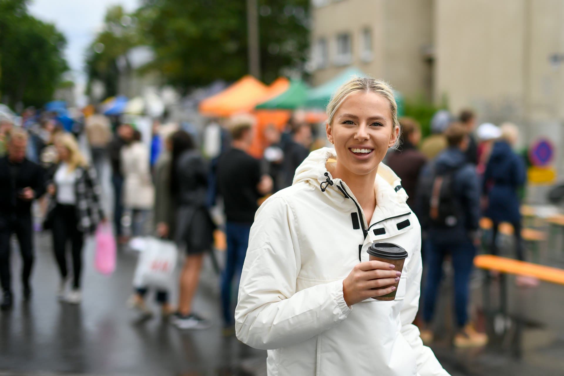 Smiling woman holding a coffee outdoors